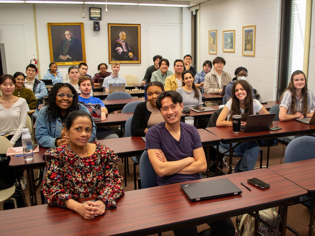 Students and Dr. Vasudevan sit together in class.